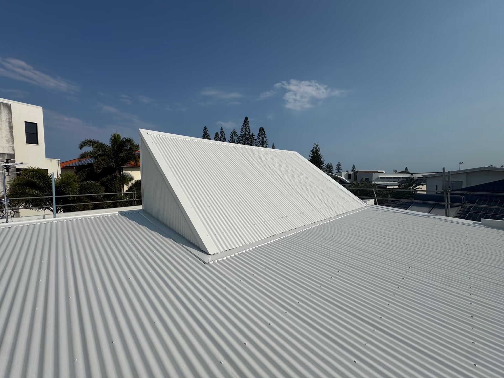 White Corrugated Metal Roof With a White Slanted Structure — Over the Top Roofing Specialists in Kunda Park, QLD
