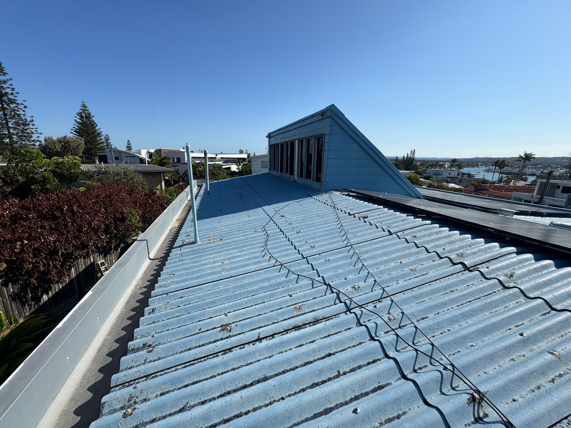 Blue corrugated metal roof with a small triangular structure.