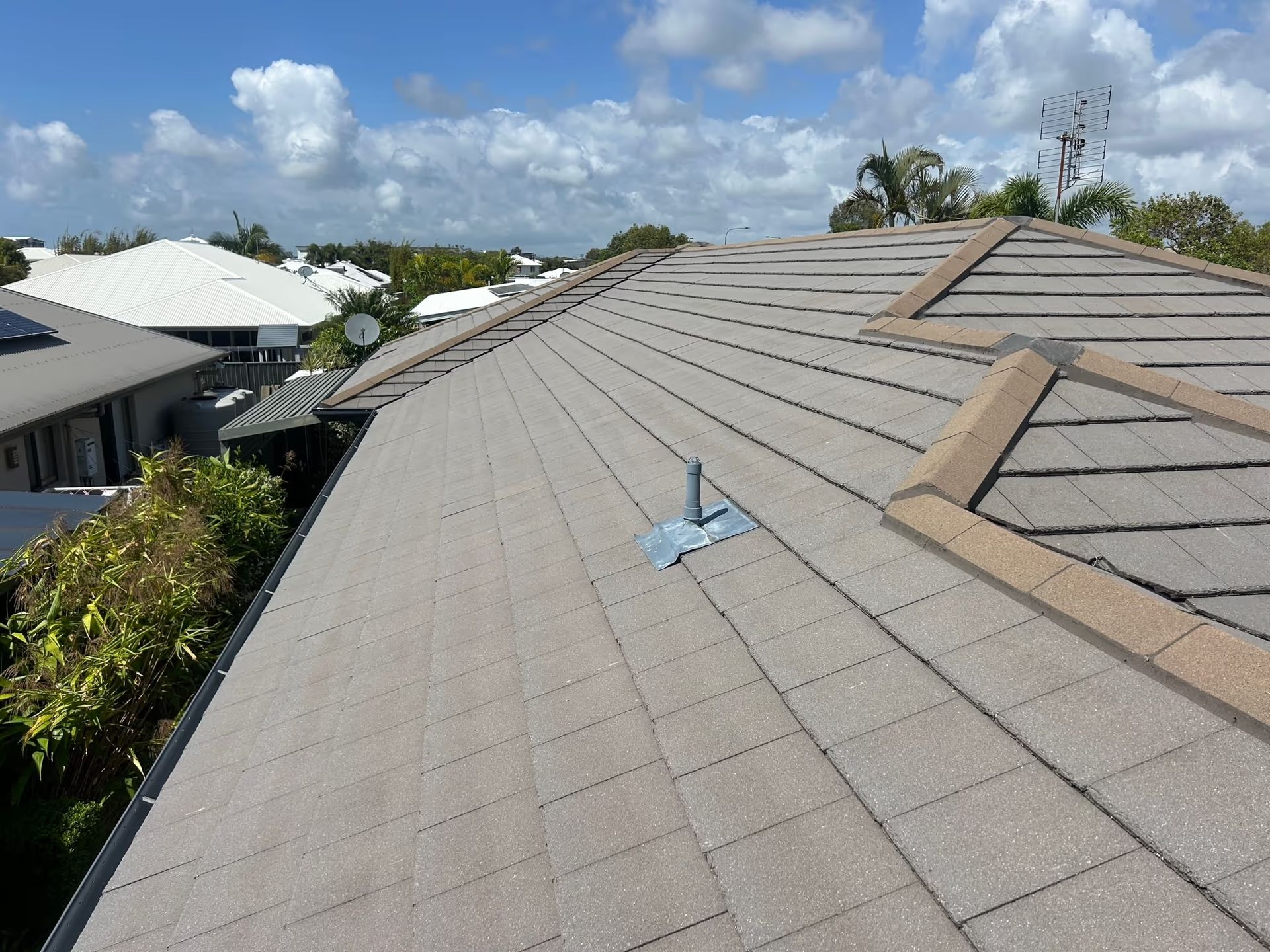 Gray Tiled Roof on a House, With a Blue Sky Visible in the Background — Over the Top Roofing Specialists in Kunda Park, QLD
