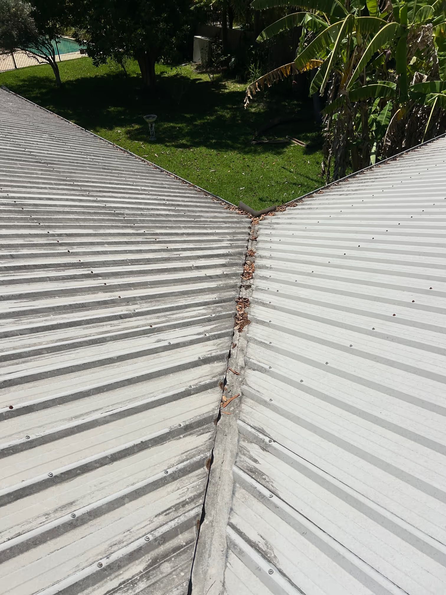 Metal Roof With Debris in a Valley, Viewed From Above — Over the Top Roofing Specialists in Kunda Park, QLD