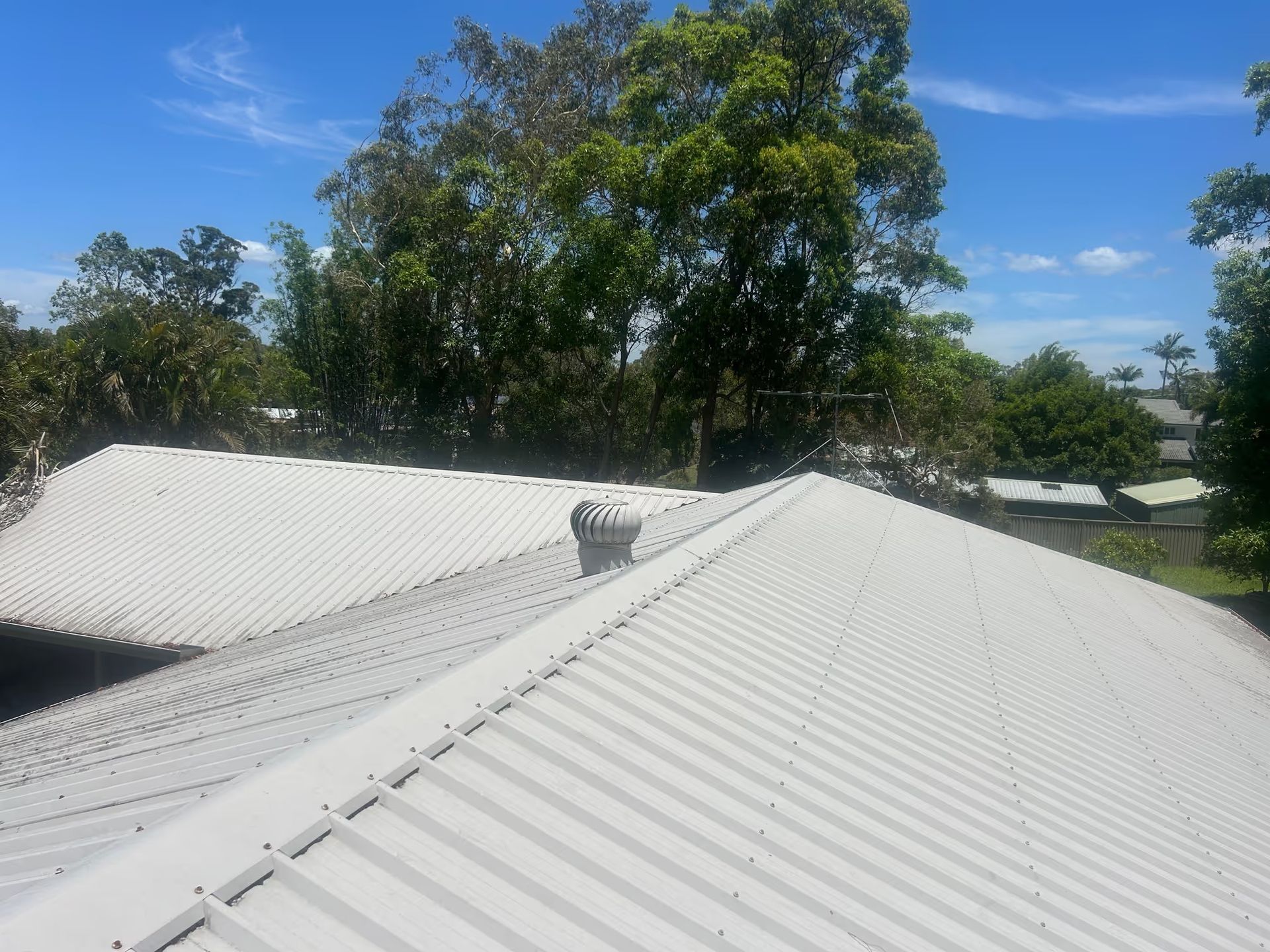 White Metal Roof With a Ventilation Unit Against a Blue Sky — Over the Top Roofing Specialists in Kunda Park, QLD