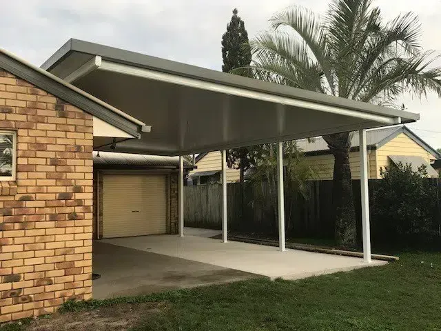 Carport Attached to a Brick House With a Concrete Driveway — Over the Top Roofing Specialists in Kallangur, QLD
