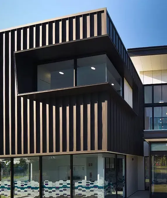 Modern Building With Dark Vertical Facade, Large Windows — Over the Top Roofing Specialists in Kunda Park, QLD