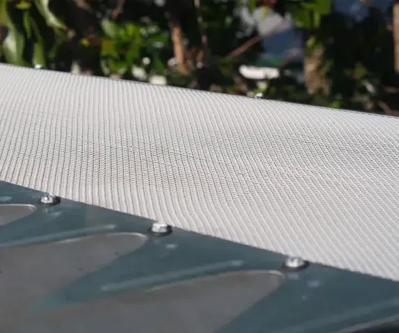 Close-up of a White Mesh Screen Attached to a Metal Gutter — Over the Top Roofing Specialists in Kunda Park, QLD