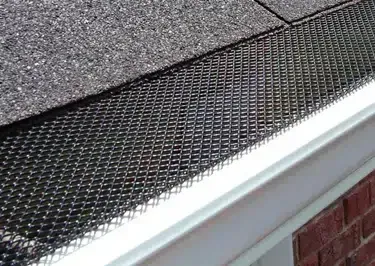 Gutter With a Wire Mesh Guard Installed Along the Roof Edge — Over the Top Roofing Specialists in Kunda Park, QLD