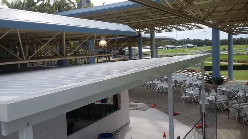 Building With a Metal Roof, Outdoor Seating, and a View of Grassy Field — Over the Top Roofing Specialists in Caloundra, QLD