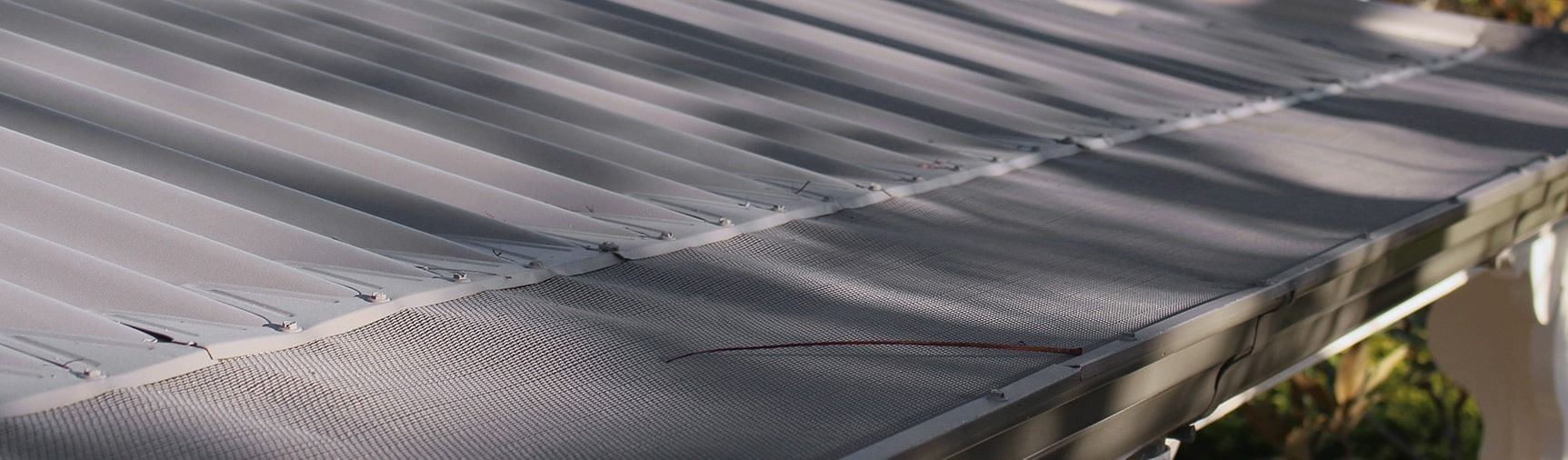 Close-up of a Corrugated Metal Roof With Shadows and a Gutter — Over the Top Roofing Specialists in Kunda Park, QLD