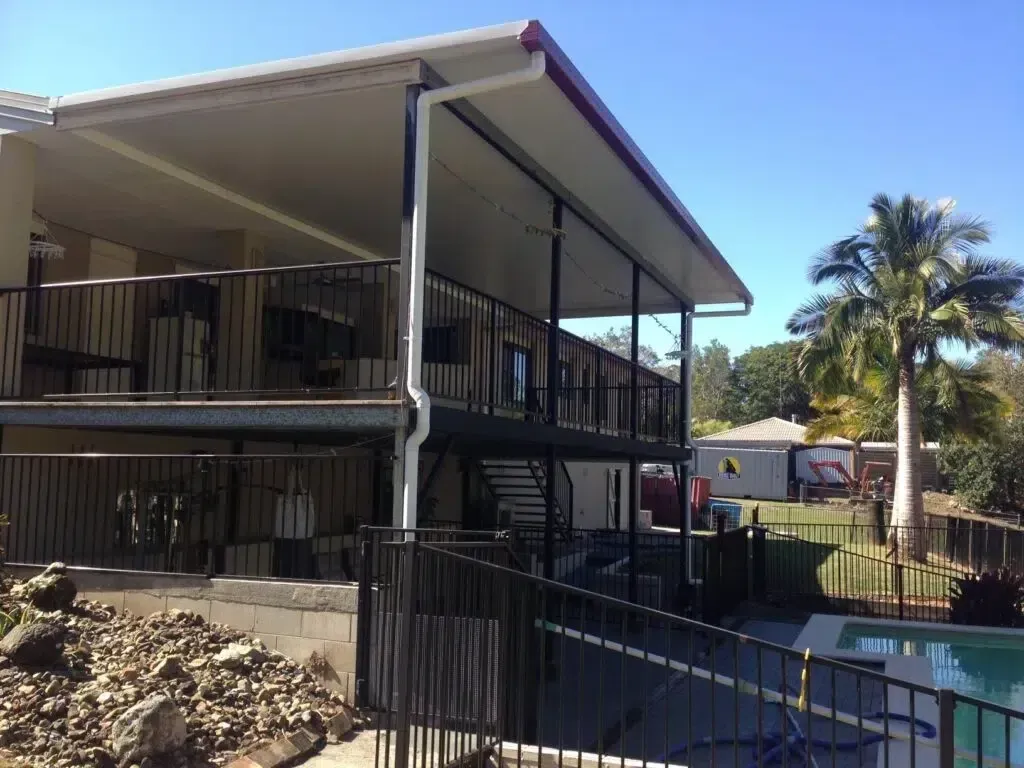 A House With Black Railing Balconies, Patio and a Swimming Pool — Over the Top Roofing Specialists in Maroochydore, QLD