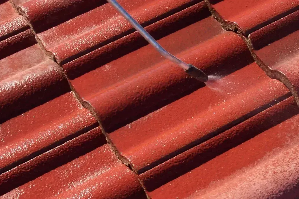Red Tiled Roof Being Cleaned With a Pressure Washer — Over the Top Roofing Specialists in Narangba, QLD