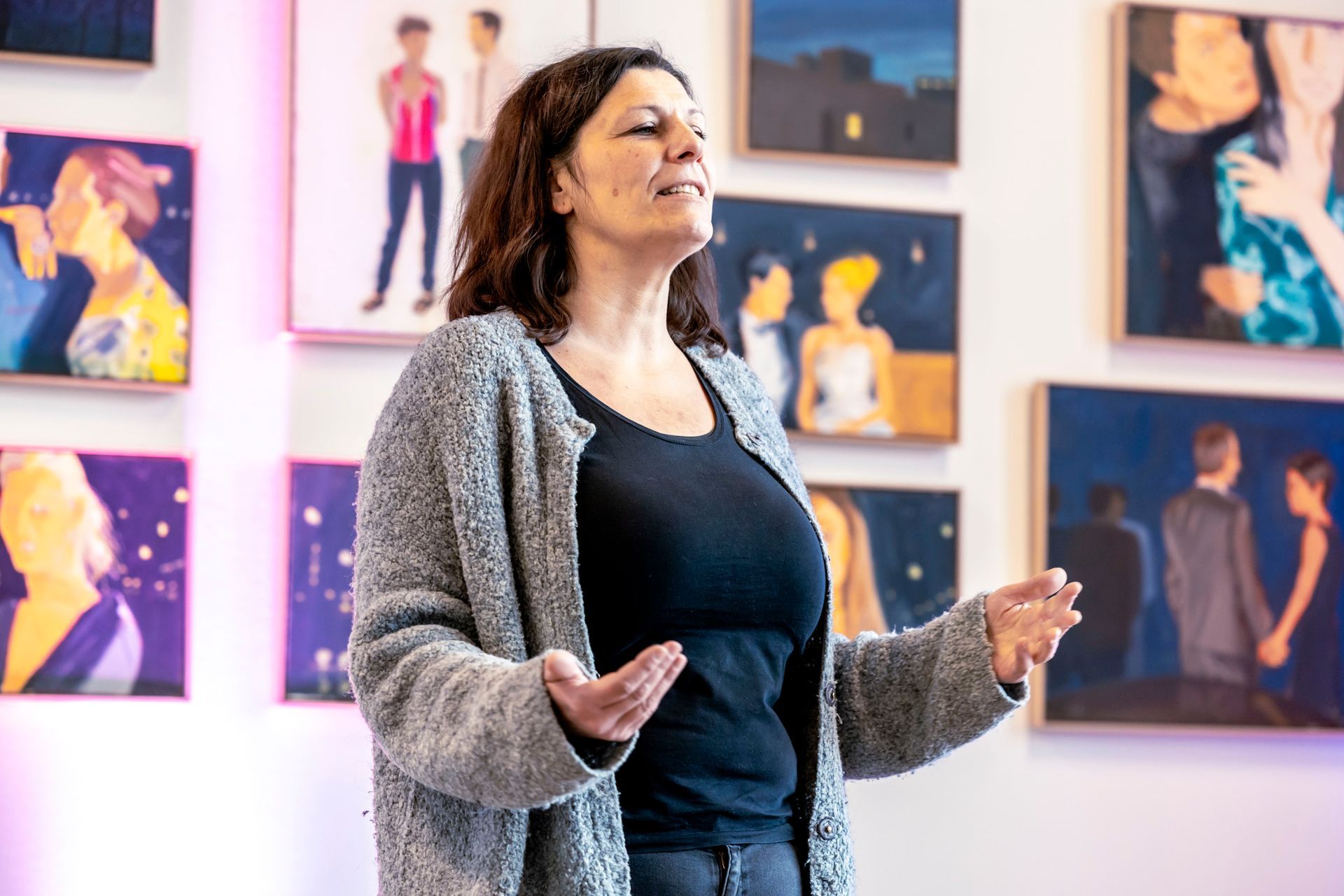 Ein Mann in einem orangefarbenen Hemd hält eine Präsentation vor einer Gruppe von Menschen