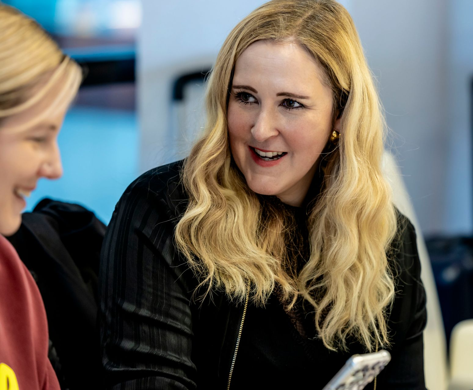 Ein Mann in einem orangefarbenen Hemd hält eine Präsentation vor einer Gruppe von Menschen