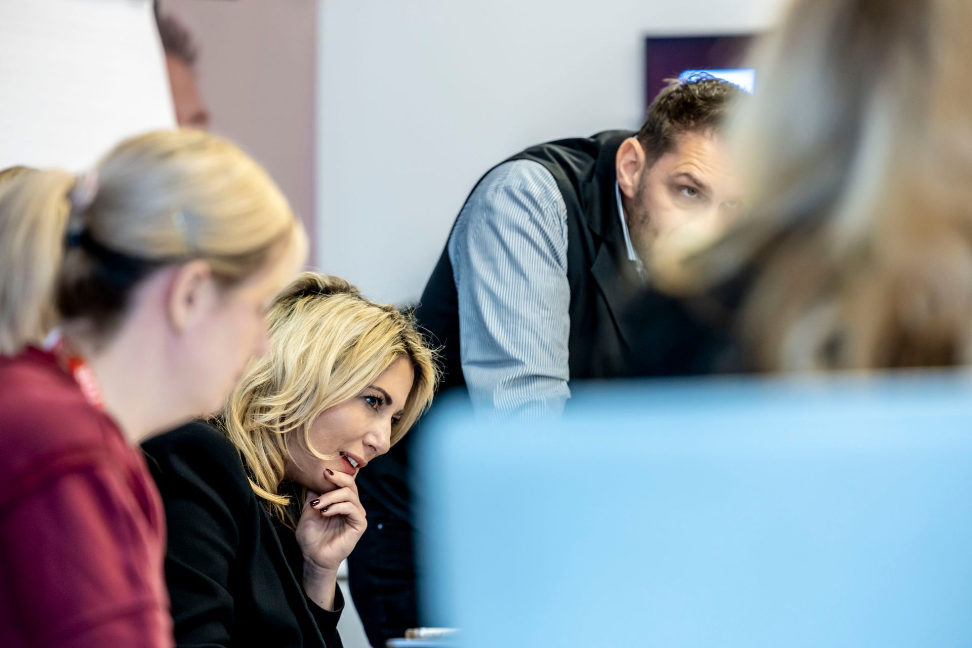 Ein Mann hält vor einer Gruppe von Leuten in einem Raum eine Präsentation.