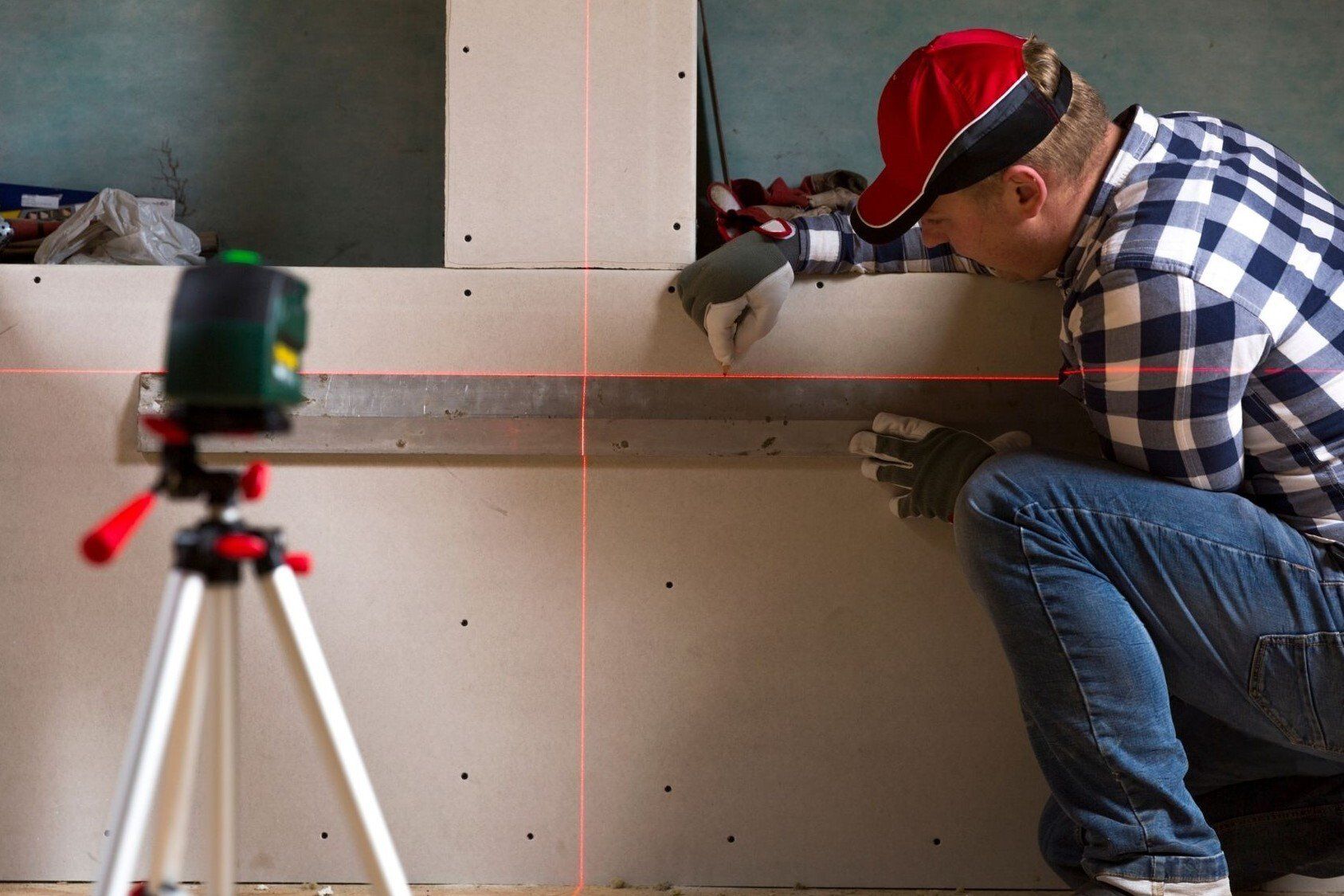 Handyman Delta installing drywall using a laser level