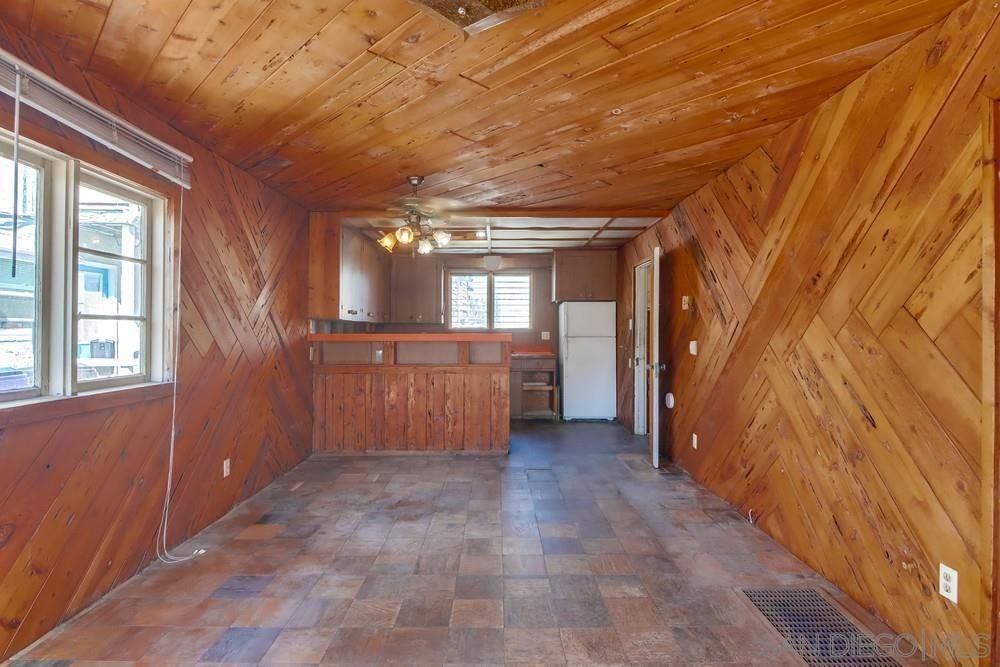 An empty room with wood paneling and tile floors