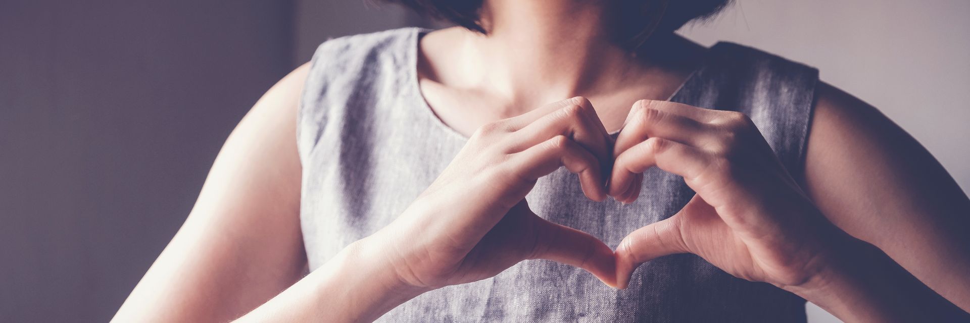 Person making a heart shape with their hands.
