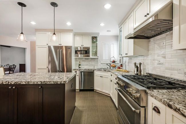 A kitchen with stainless steel appliances and granite counter tops.