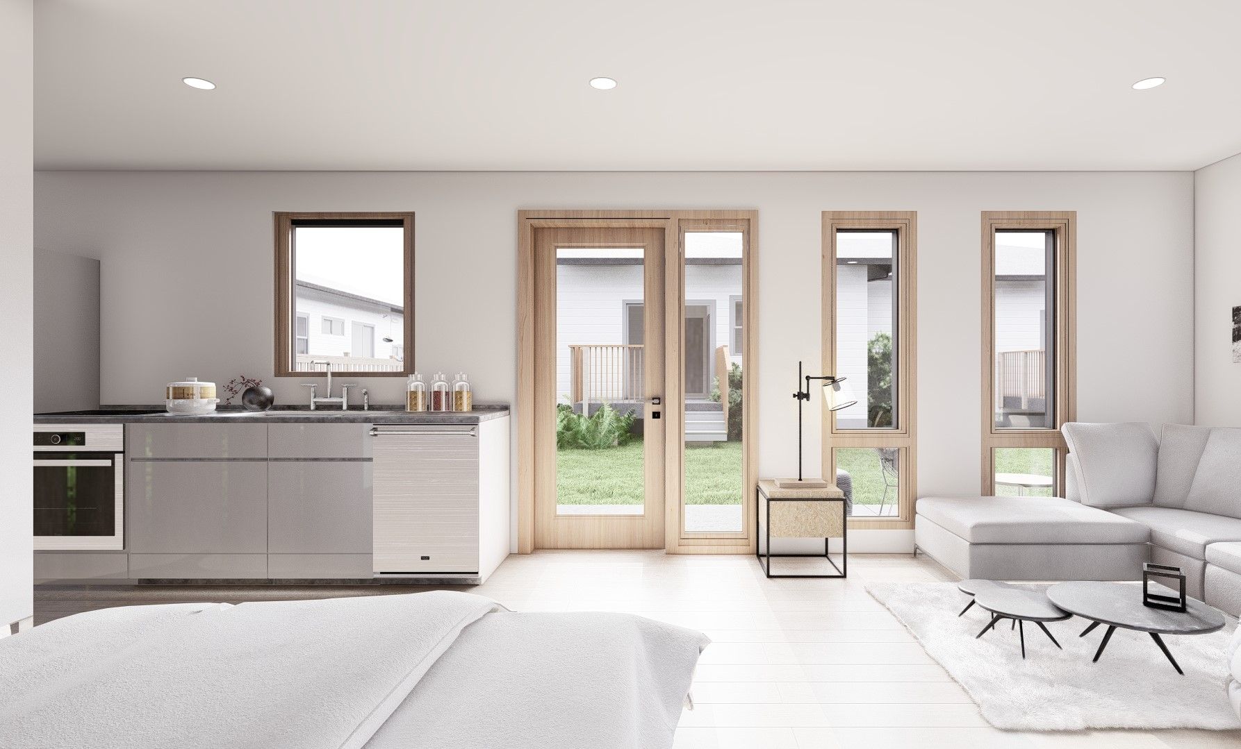 A living room with a couch and a kitchen with a lot of windows.