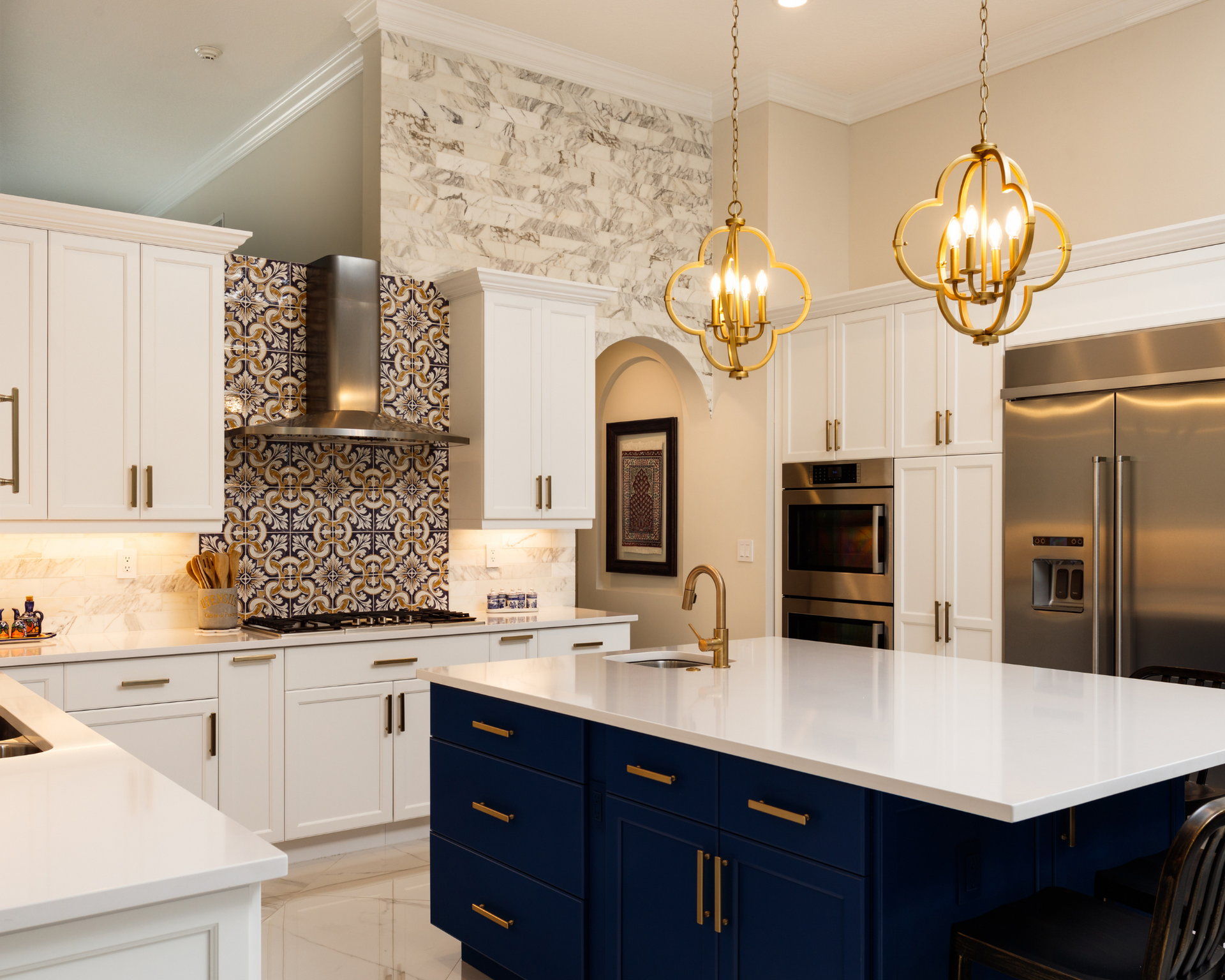 A kitchen with white cabinets , blue cabinets , and stainless steel appliances.