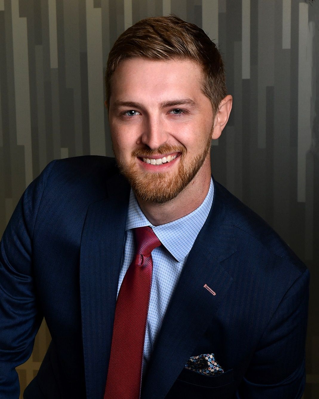 A man in a suit and tie is smiling for the camera.