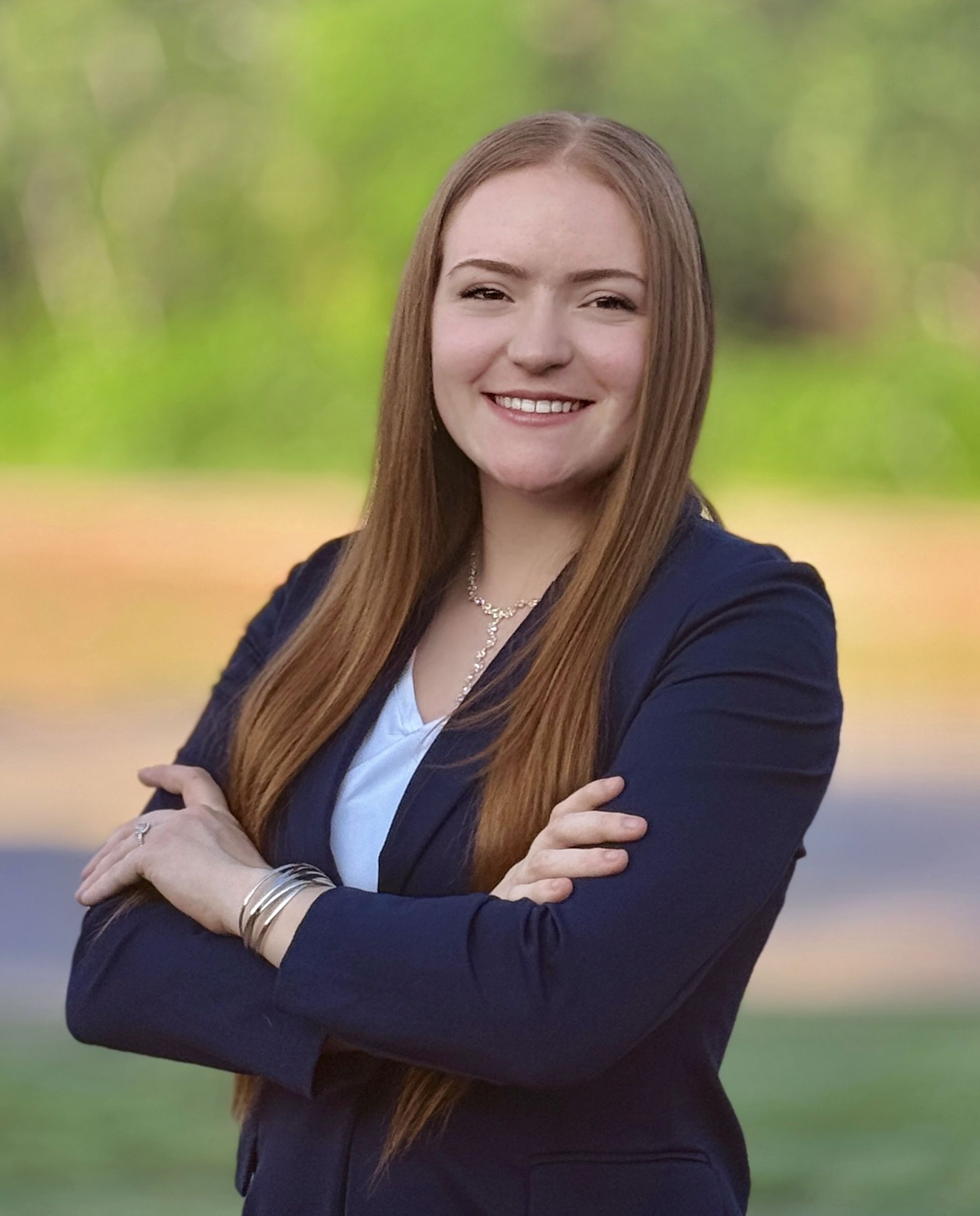 A woman with long black hair is wearing a pink shirt