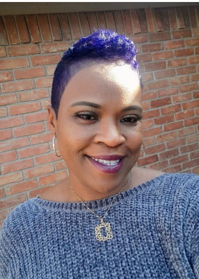 A woman with long black hair is wearing a pink shirt