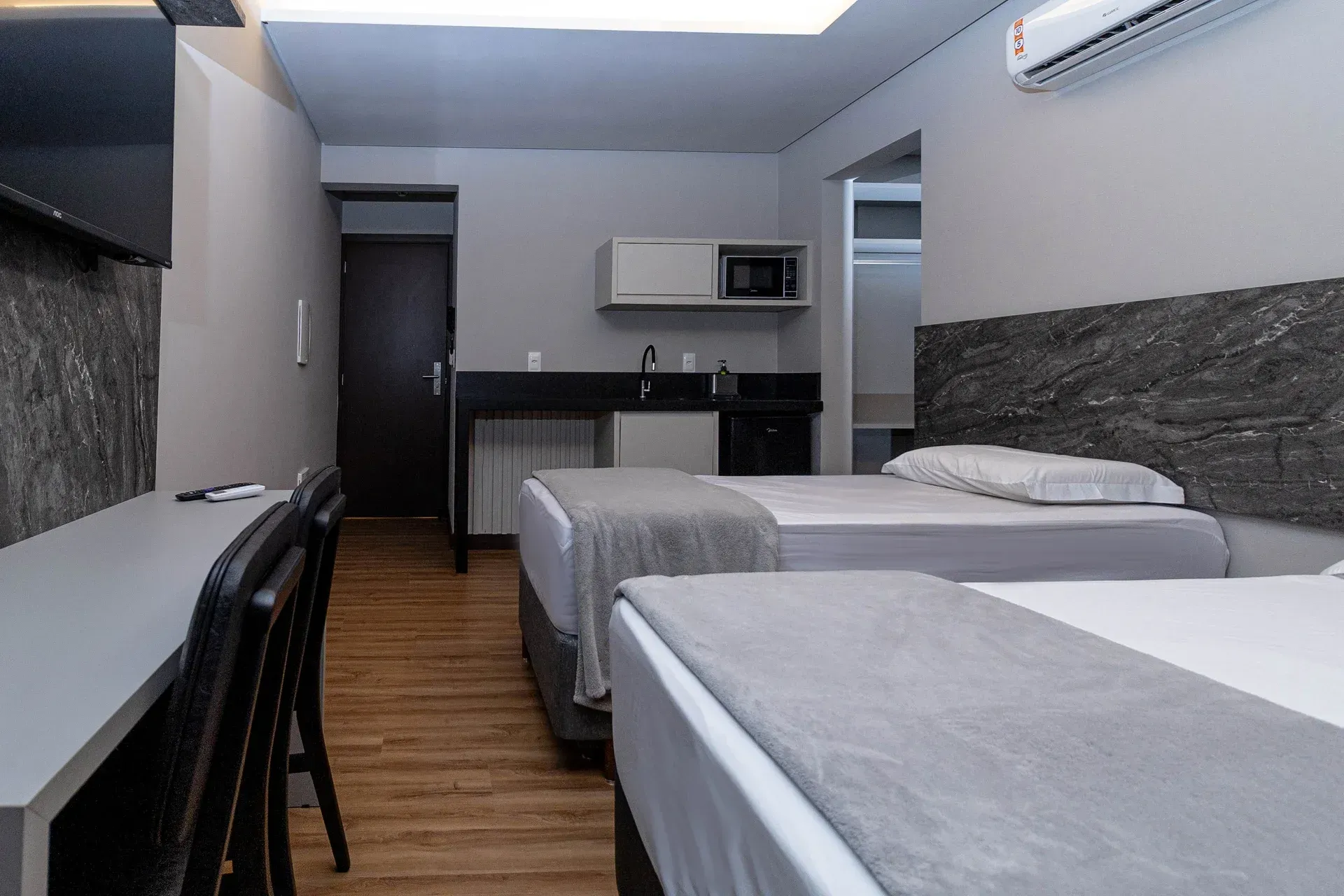 Um quarto de hotel com duas camas e uma escrivaninha.