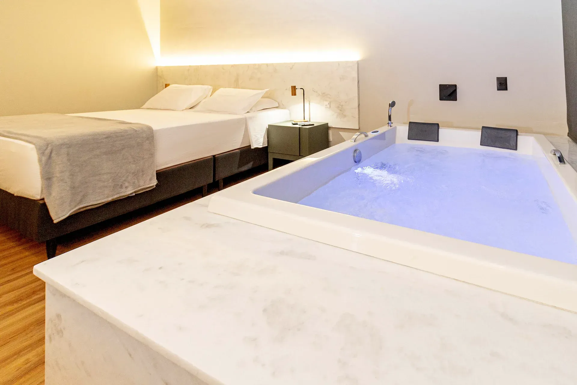 Um quarto de hotel com uma banheira de hidromassagem ao lado da cama.