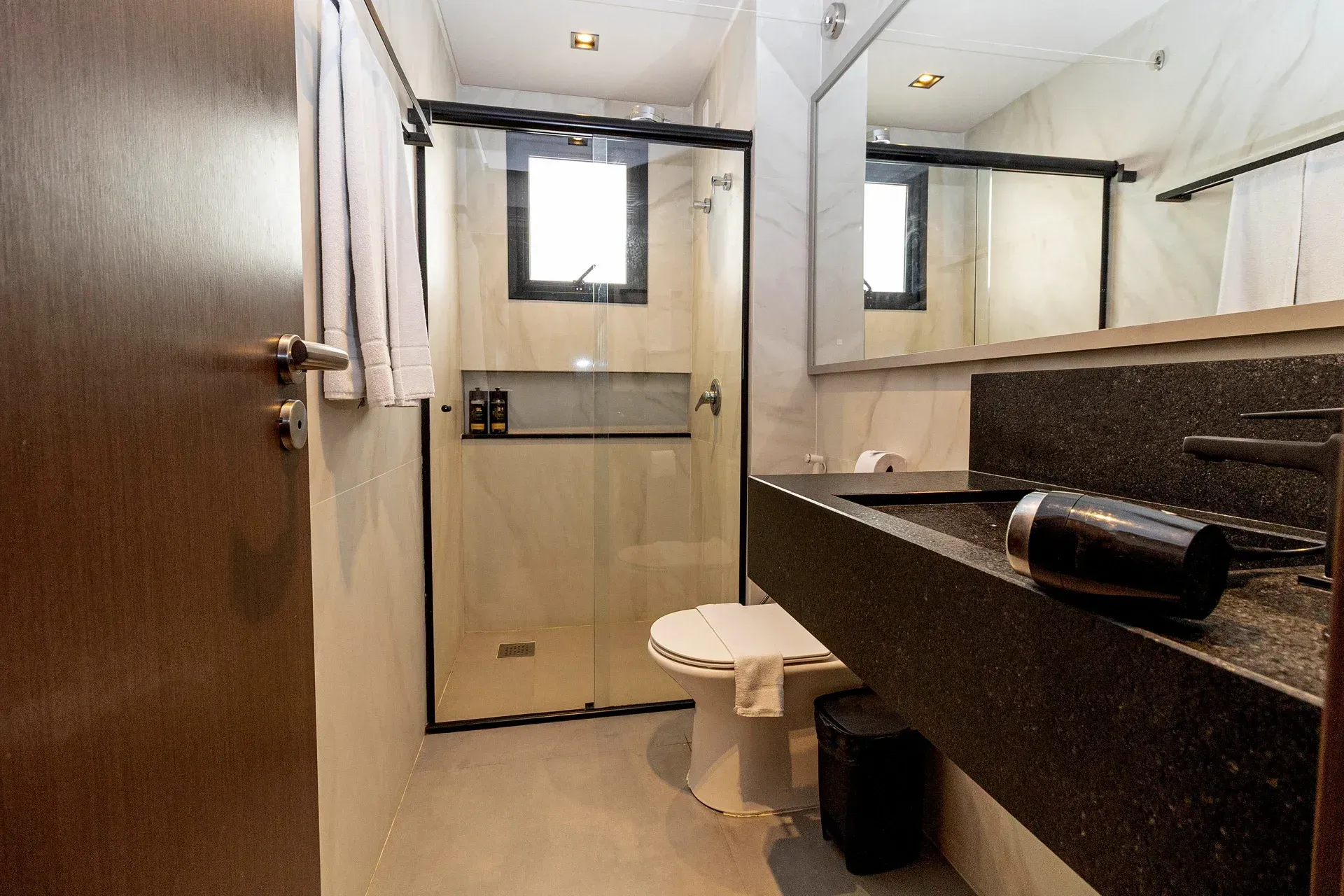 Um banheiro com vaso sanitário, pia e chuveiro.