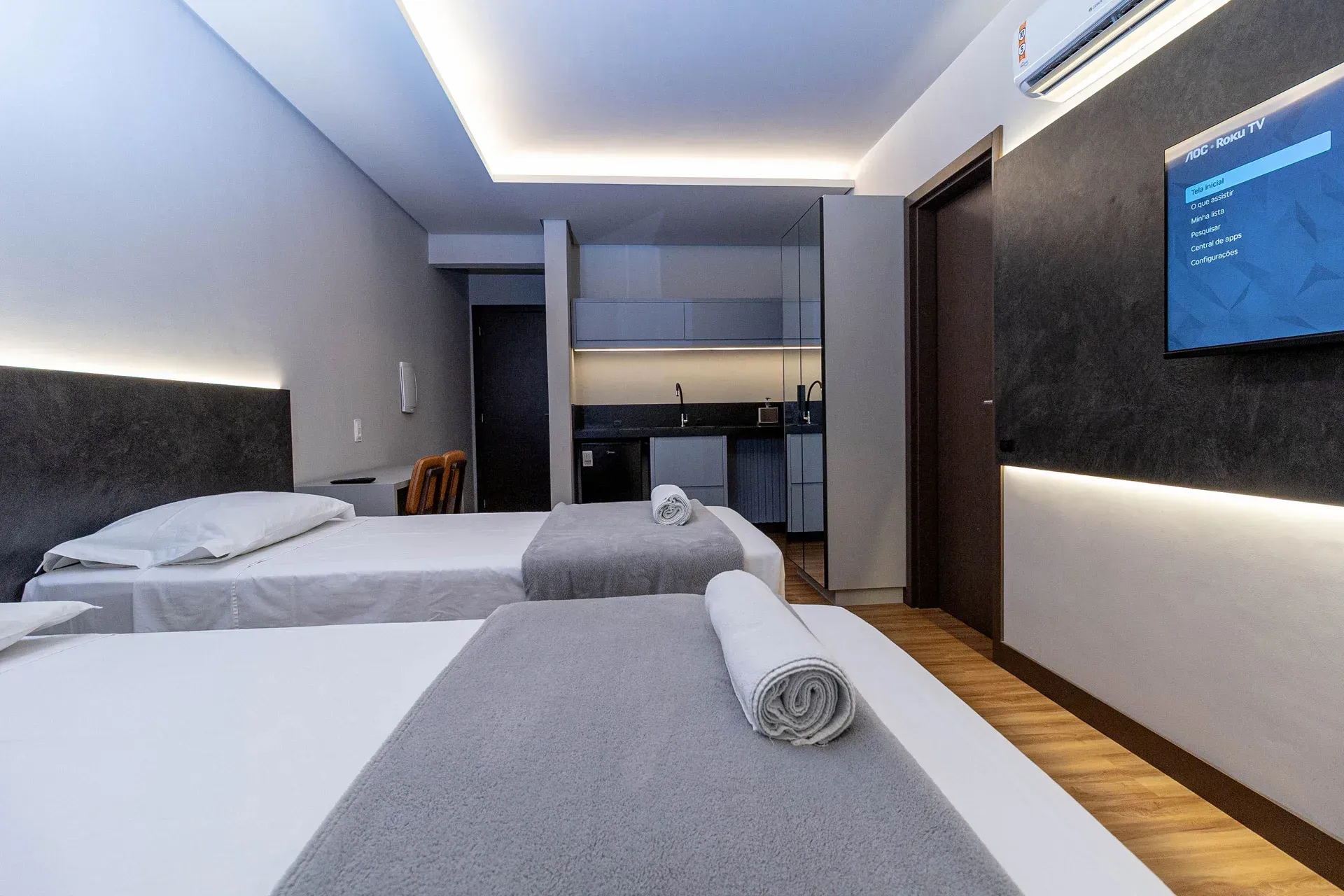 Um quarto de hotel com duas camas e uma TV de tela plana.