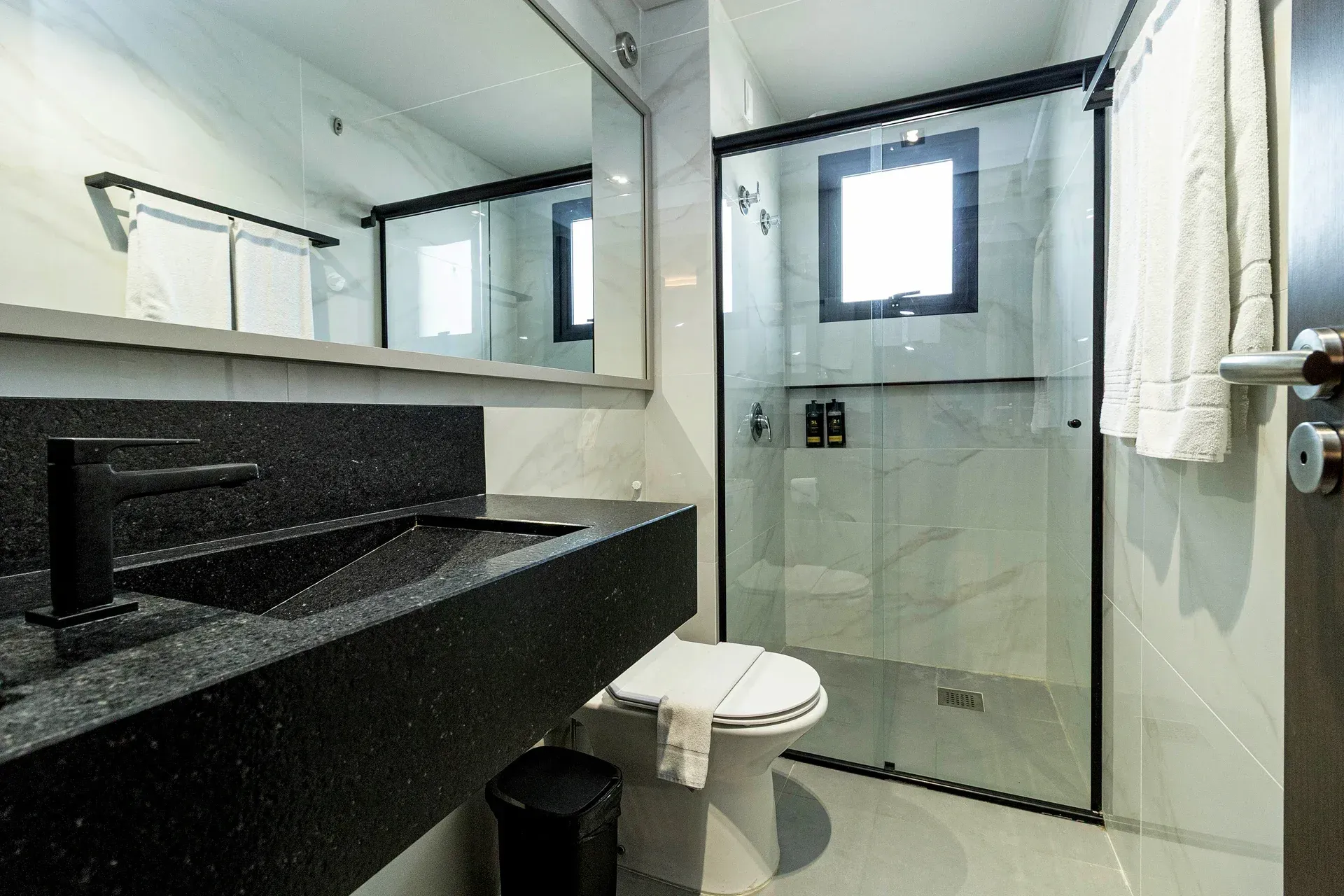 Um banheiro com vaso sanitário, pia e chuveiro.