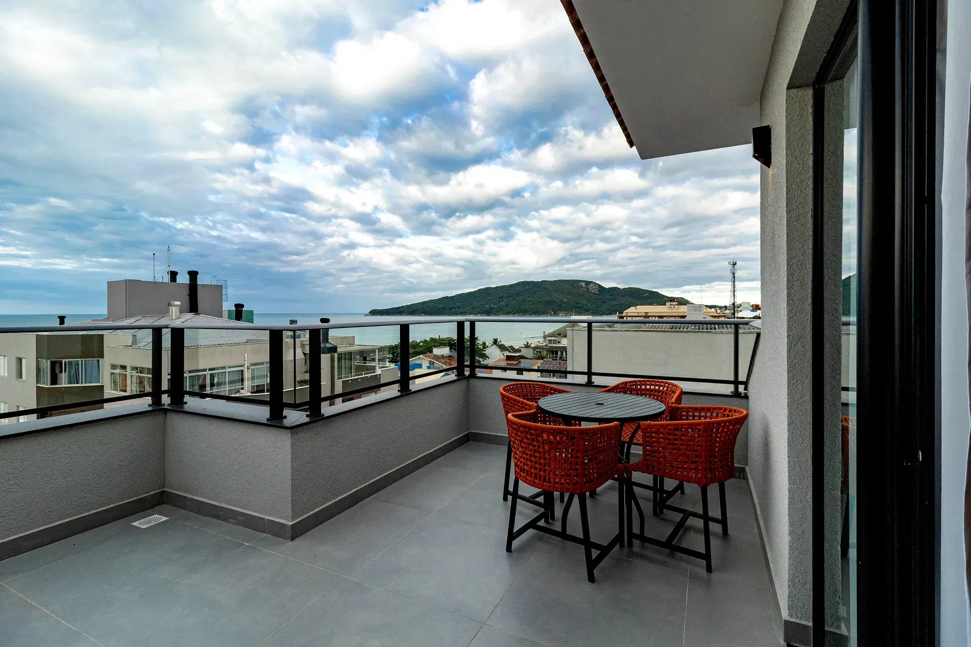 Uma varanda com mesa e cadeiras e vista para o oceano.
