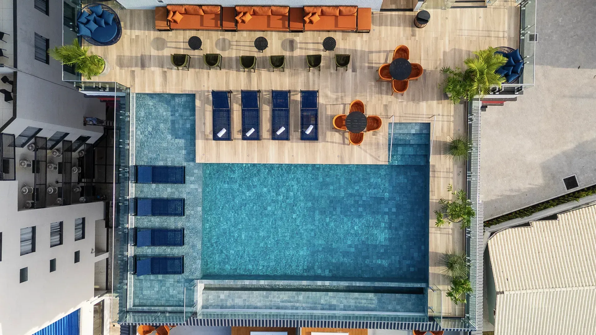 Uma vista aérea de uma grande piscina cercada por cadeiras e mesas