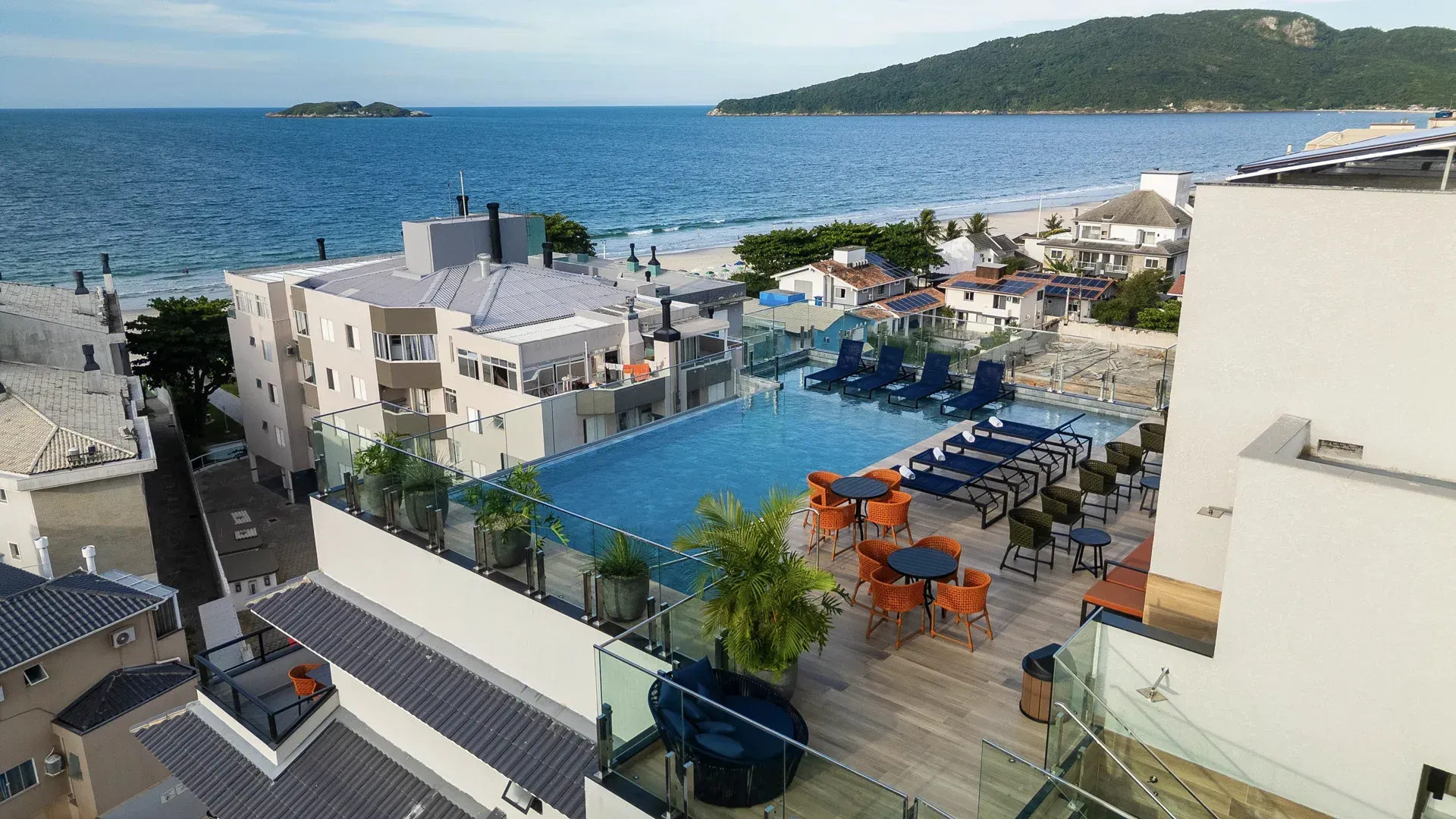 Uma vista aérea de um hotel com piscina com vista para o oceano.