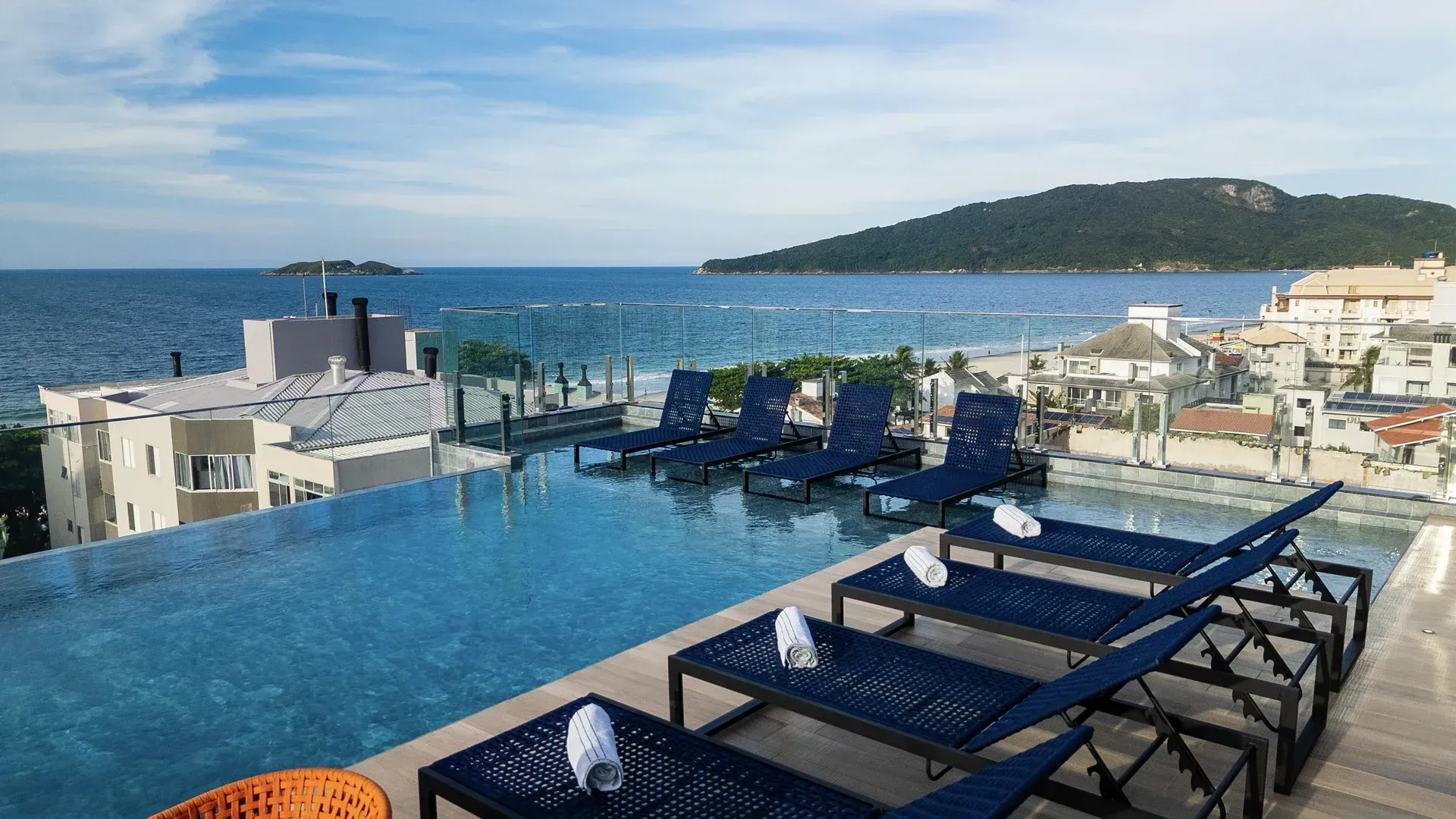 Há uma piscina no telhado de um prédio com vista para o oceano.