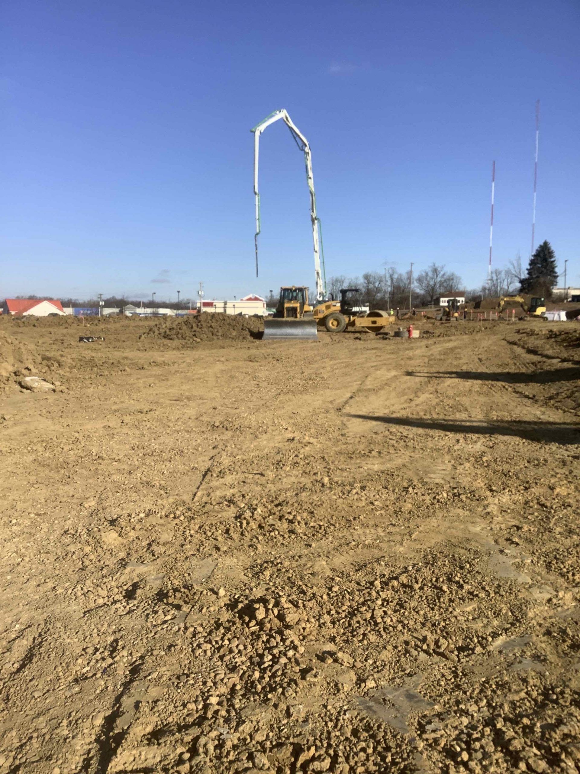 A construction site with a concrete pump in the middle of it.