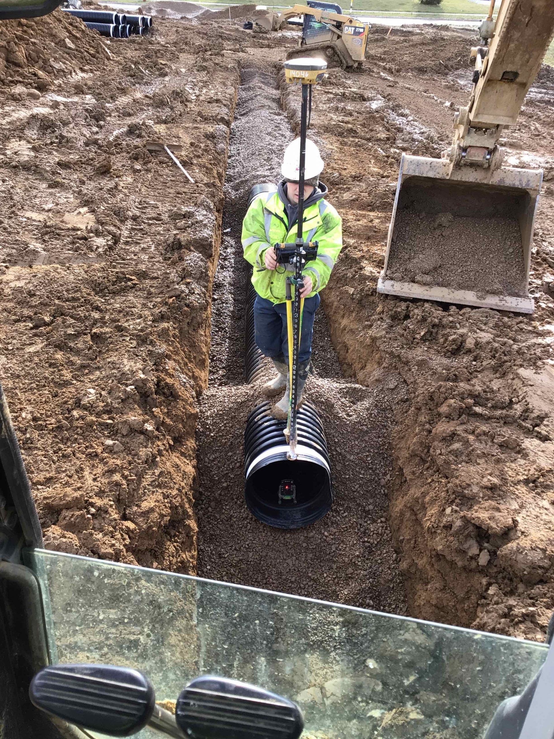 A man is digging a hole in the dirt with a shovel.