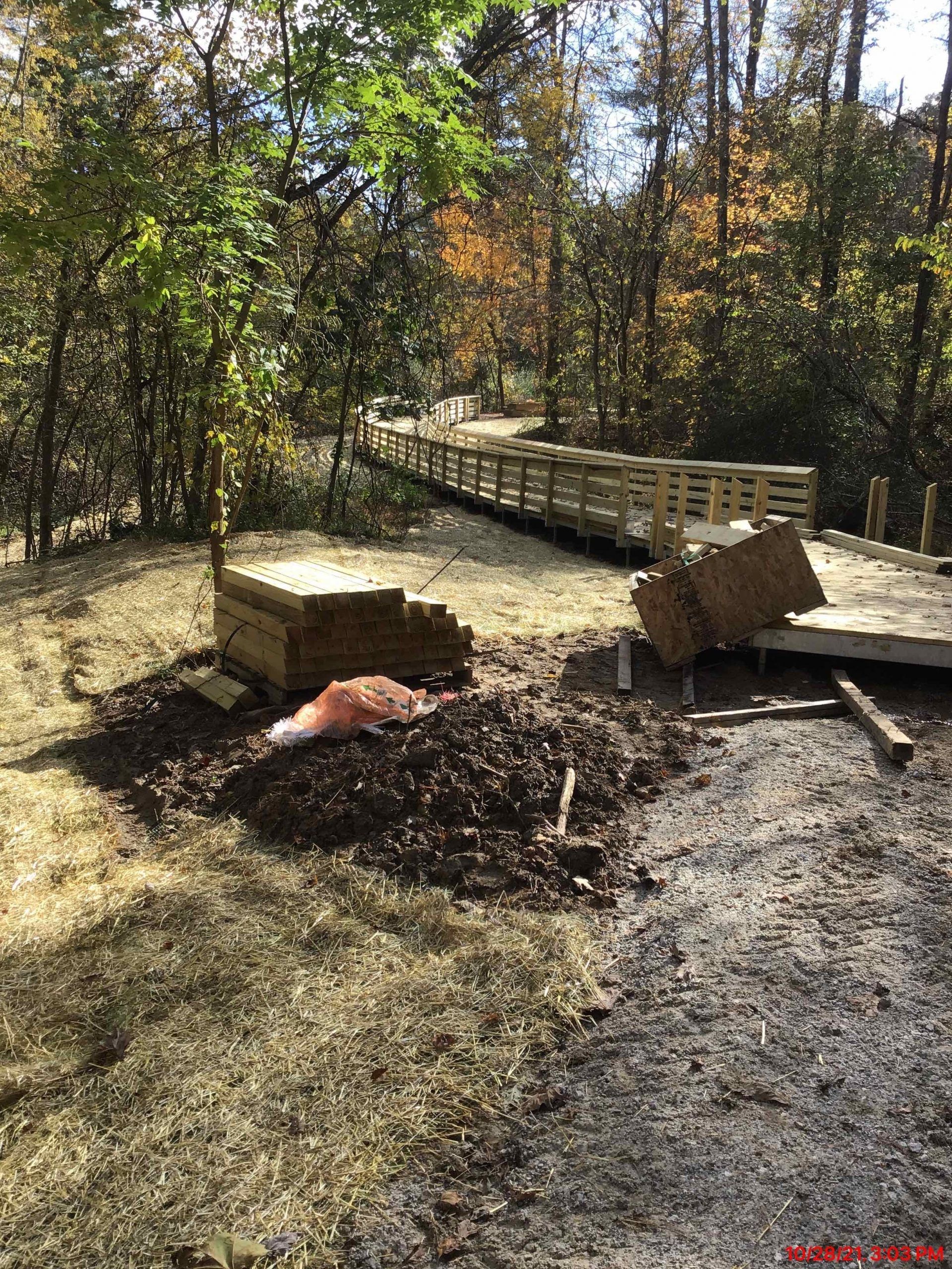 A wooden bridge is being built in the middle of a forest.