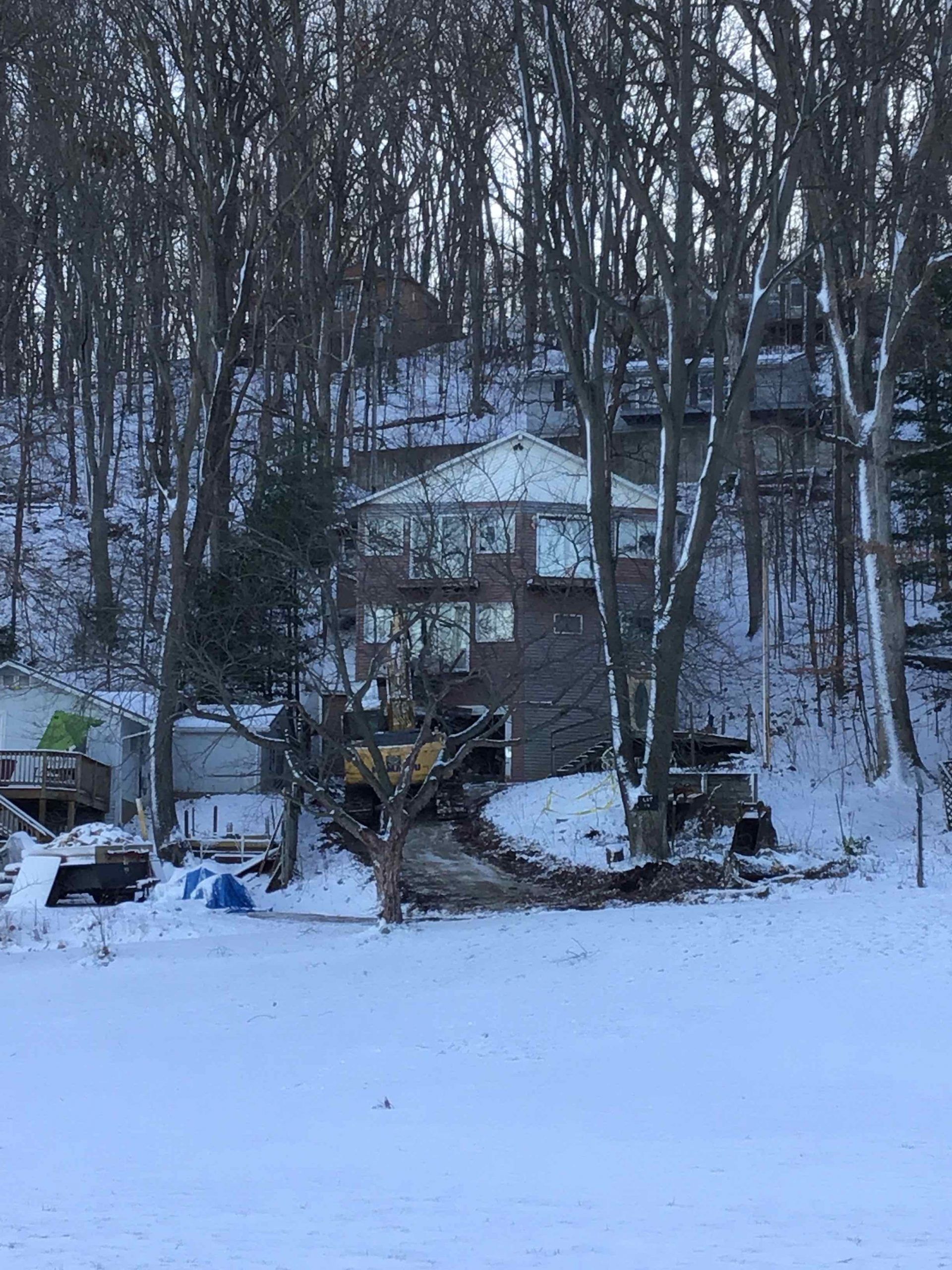 A house is sitting in the middle of a snowy forest.