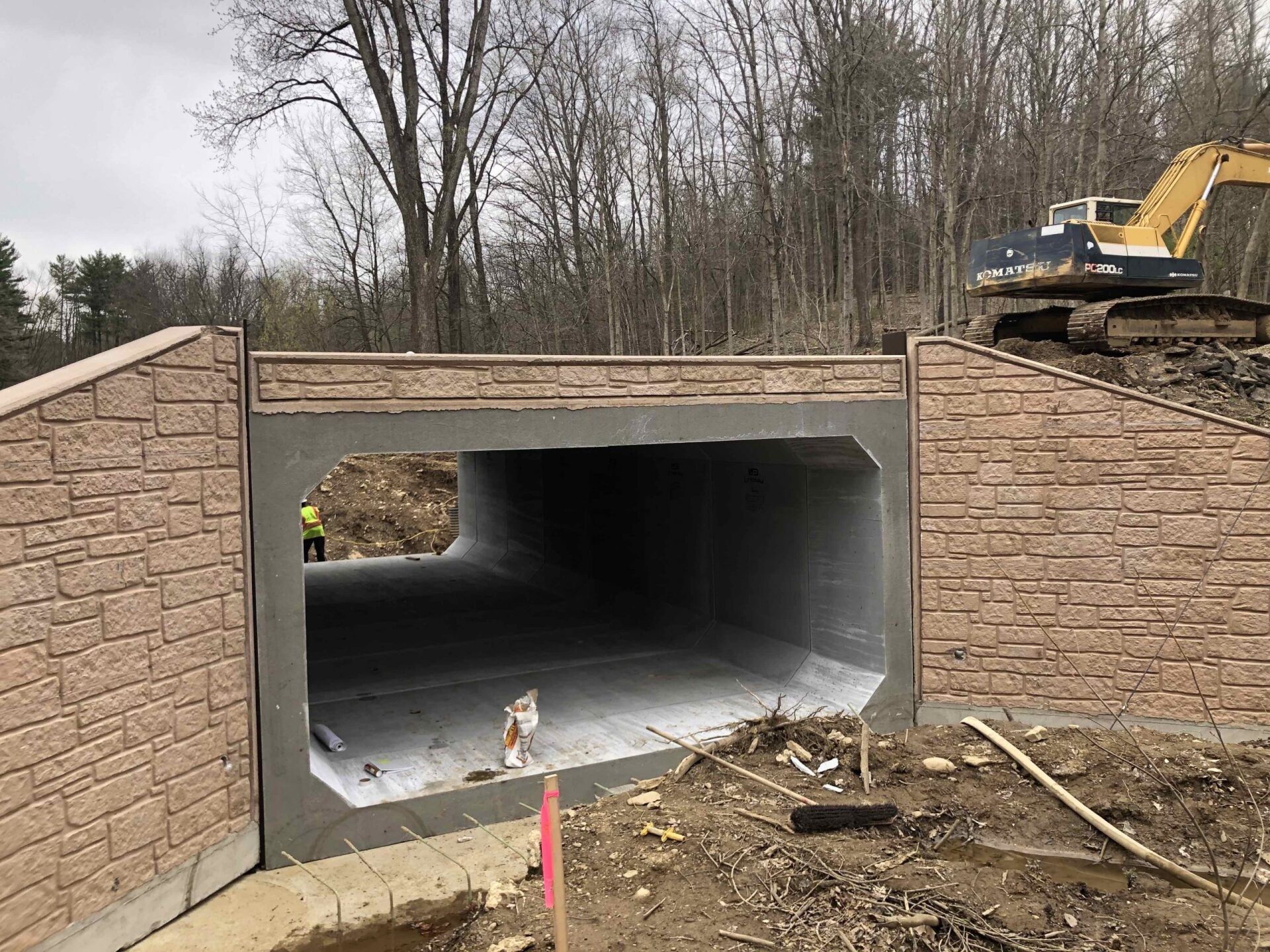 A construction site with a brick wall and a tunnel underneath it.