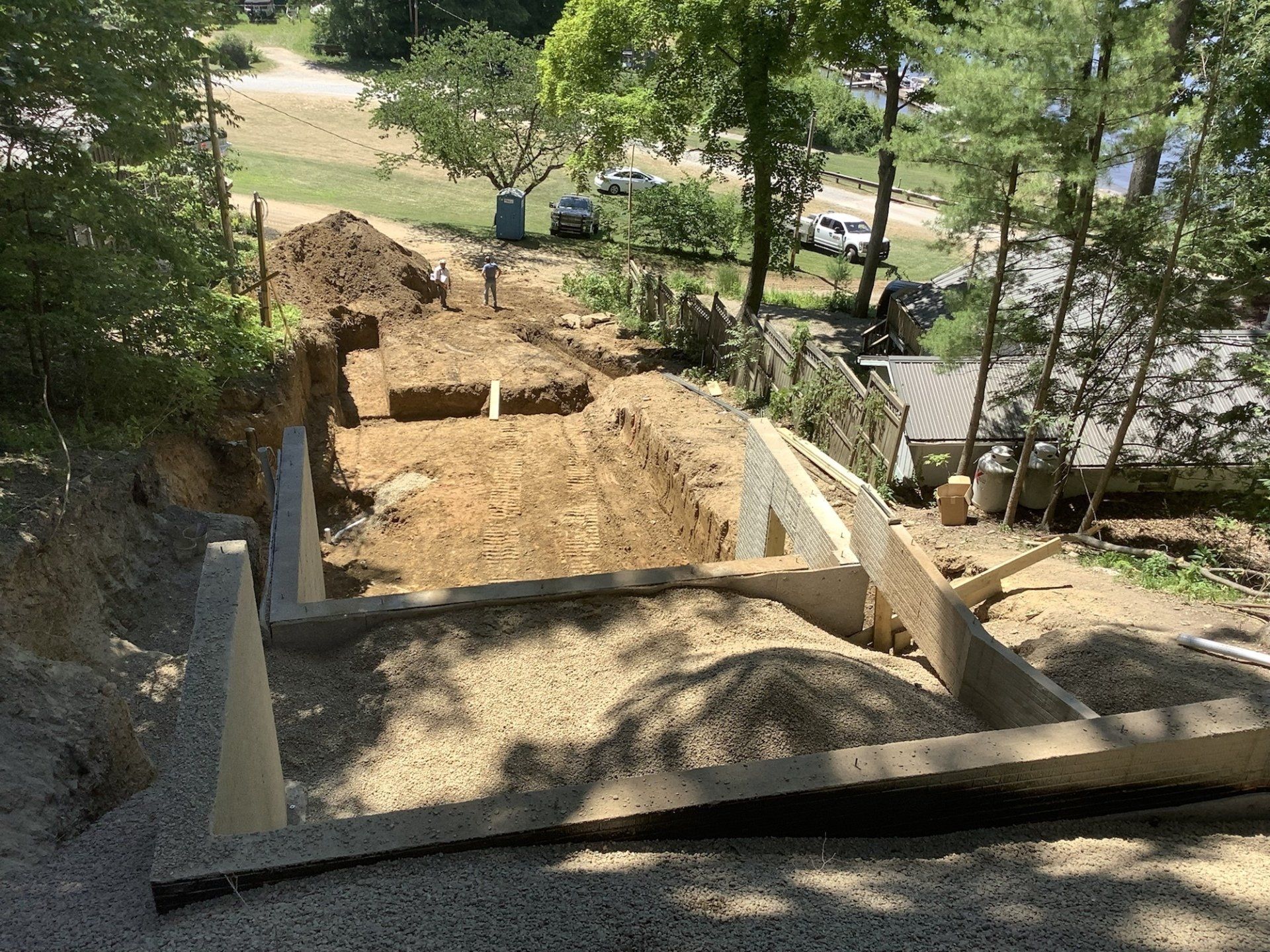 A construction site with a lot of dirt and trees in the background.