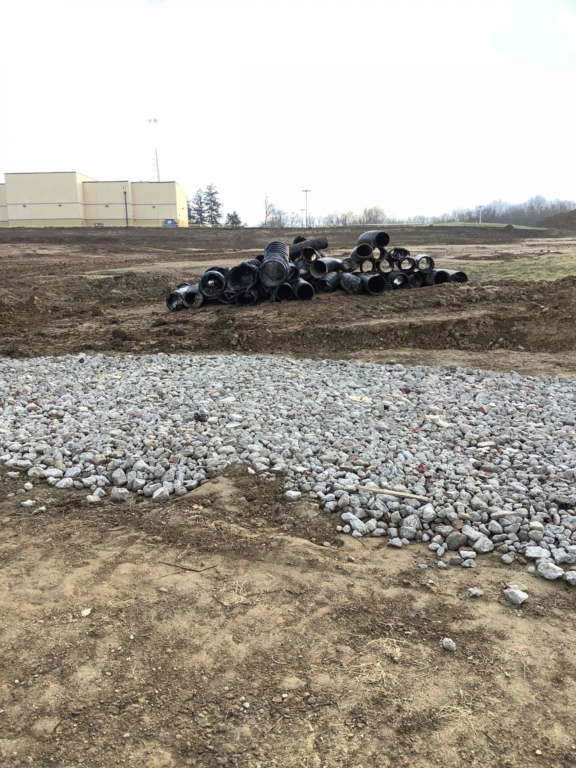 A bunch of tires are laying on the ground in a field.