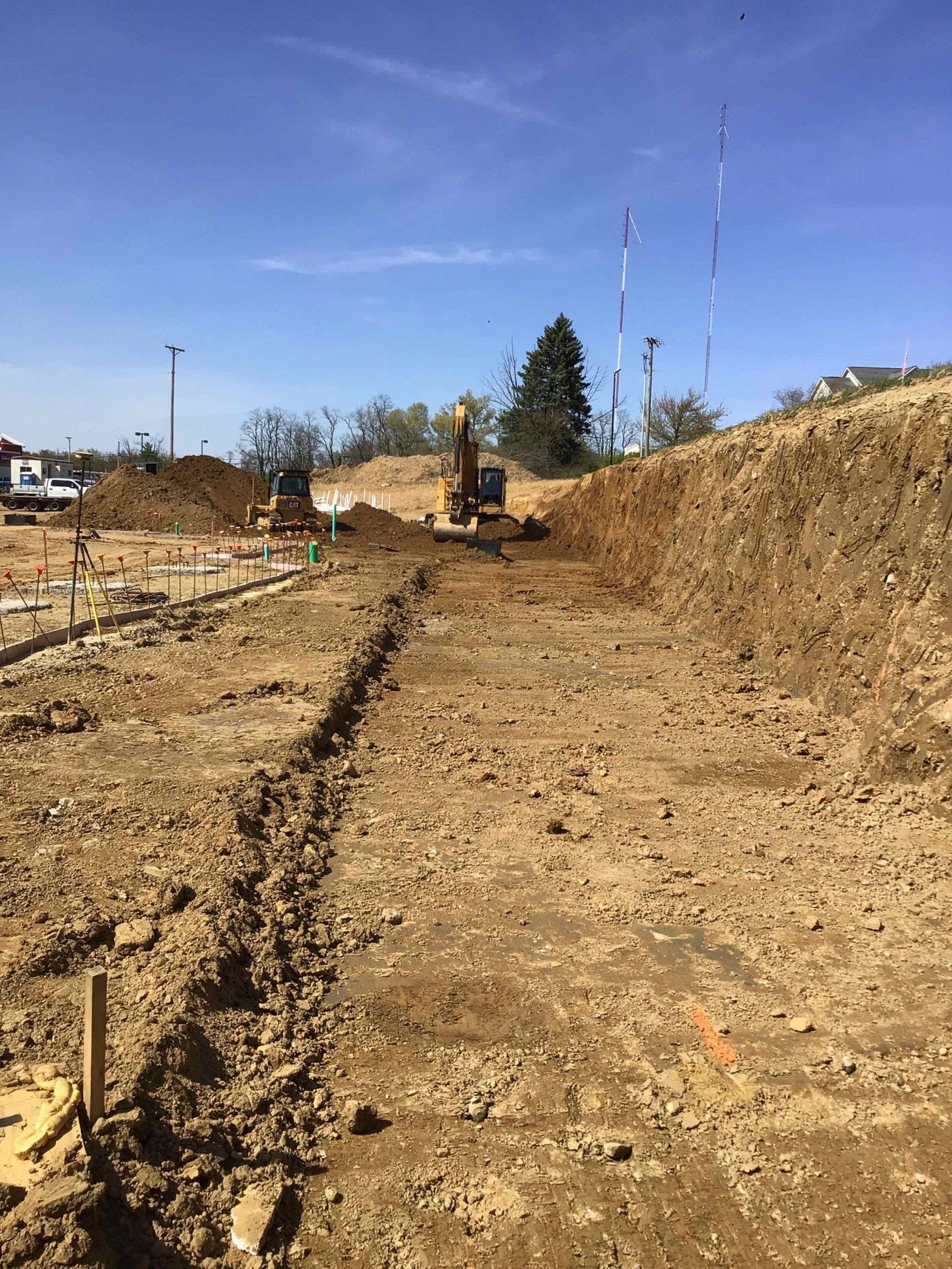 A bulldozer is digging a trench in the dirt on a construction site.