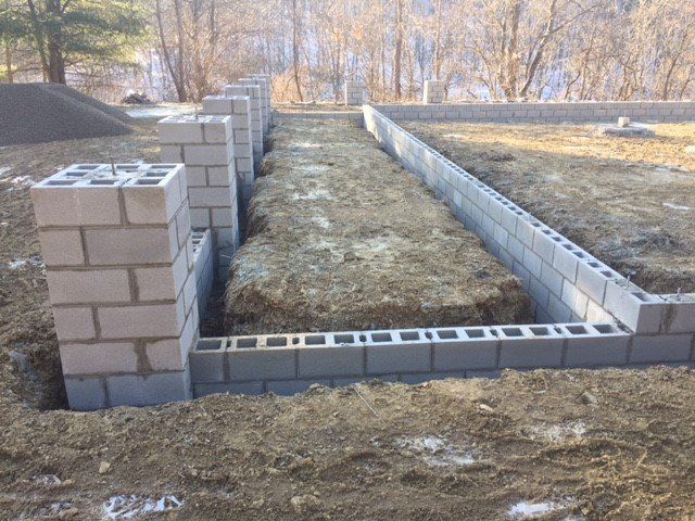 A brick wall is being built in the dirt