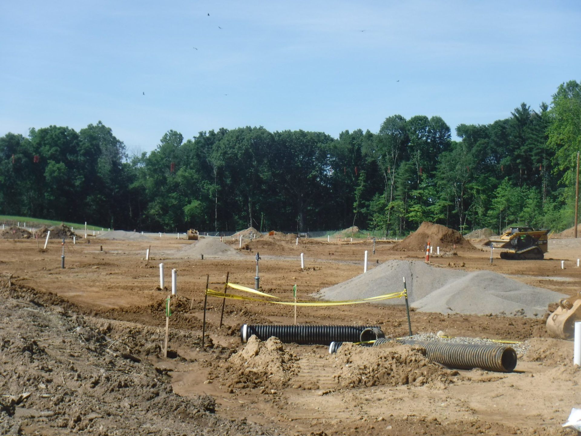 A construction site with a lot of dirt and trees in the background