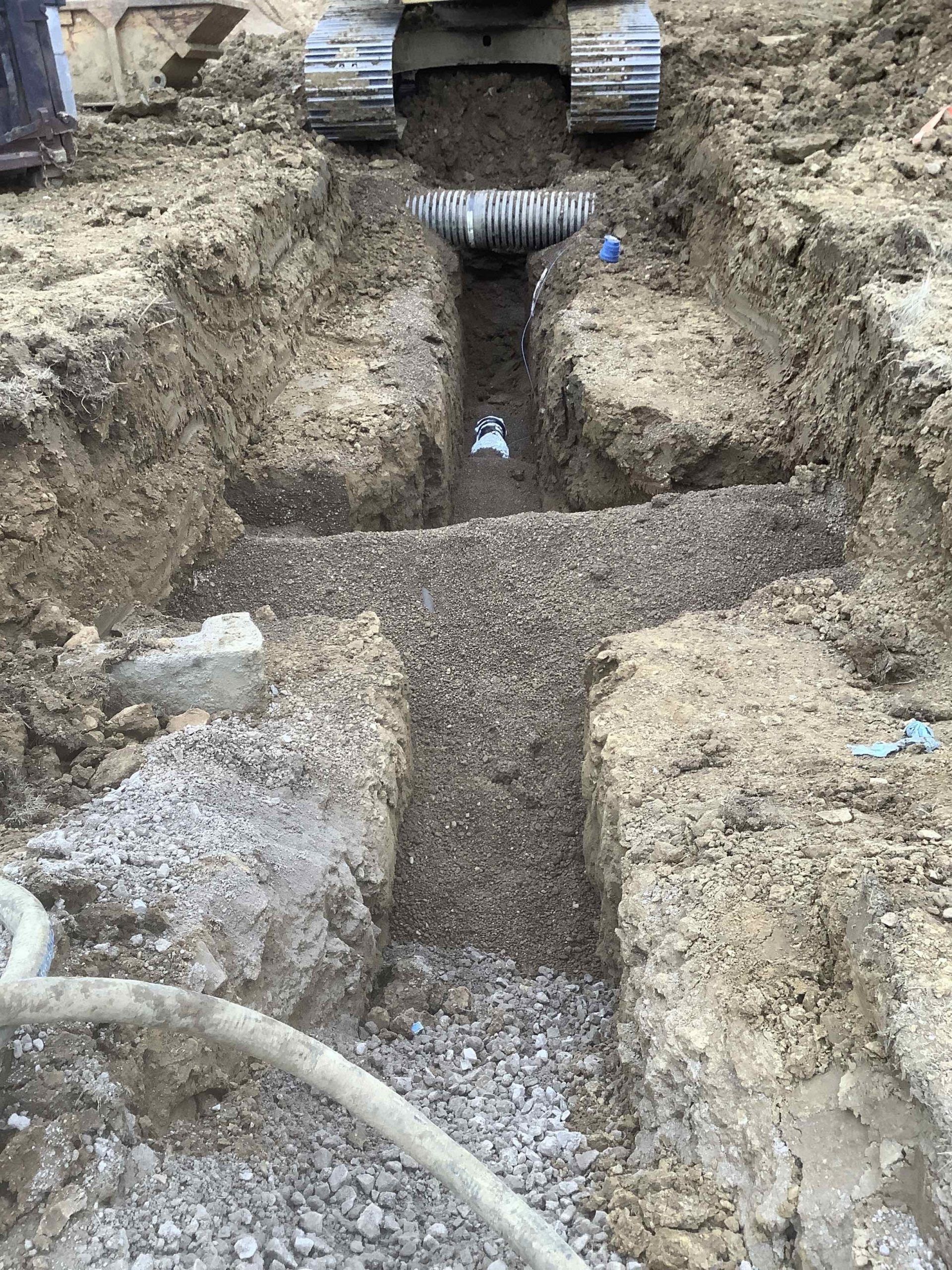 A bulldozer is digging a trench in the dirt.