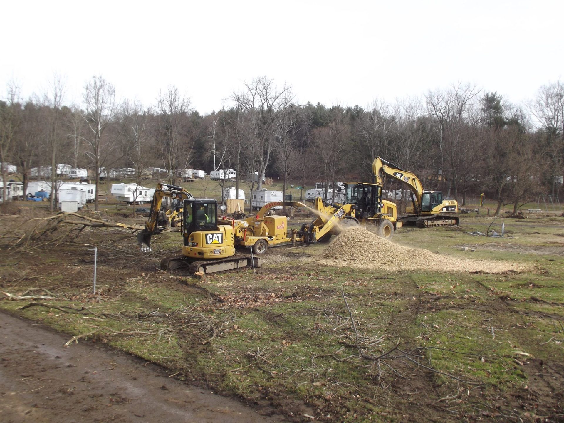 A group of construction vehicles are working in a field.