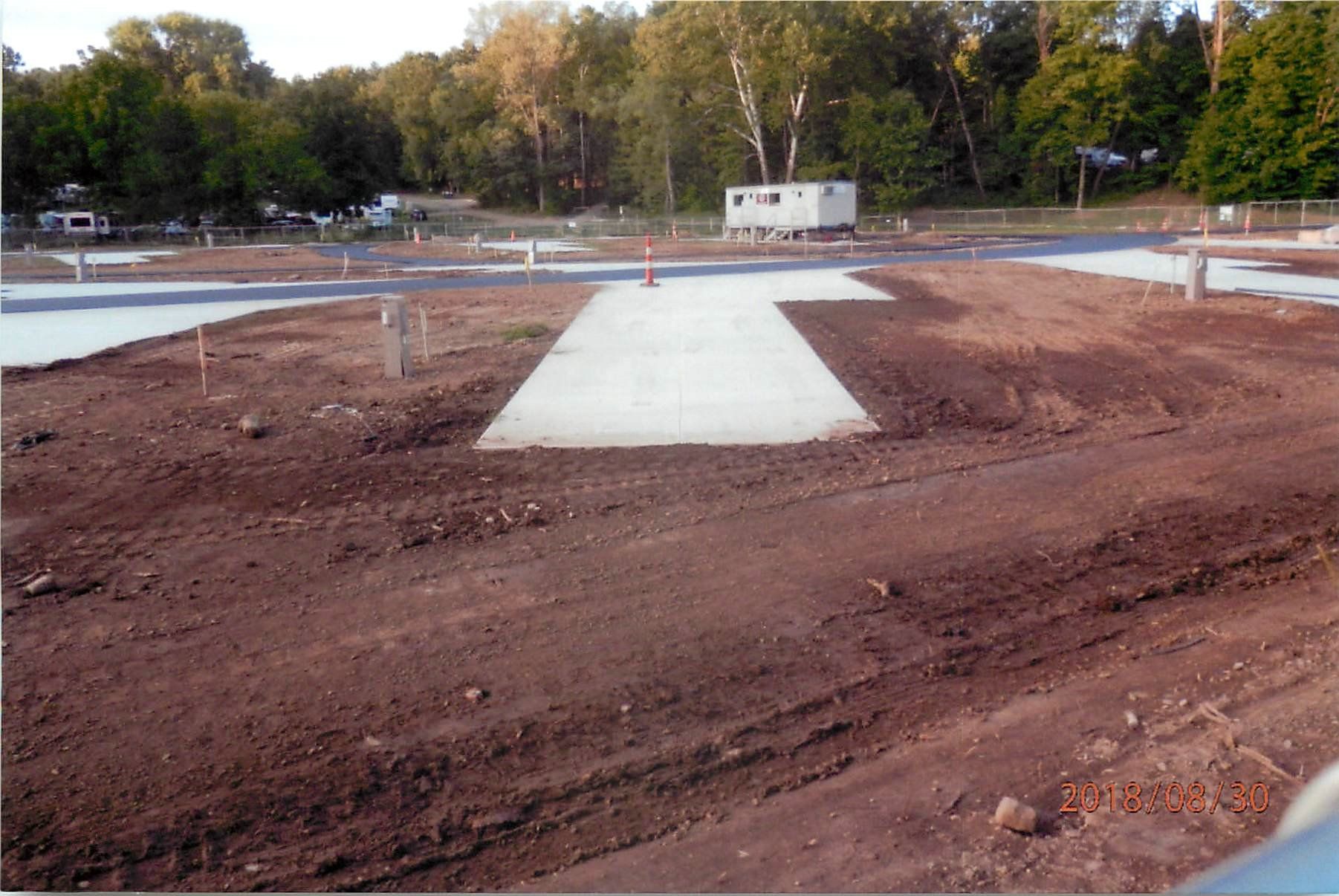 A concrete walkway in the middle of a dirt field