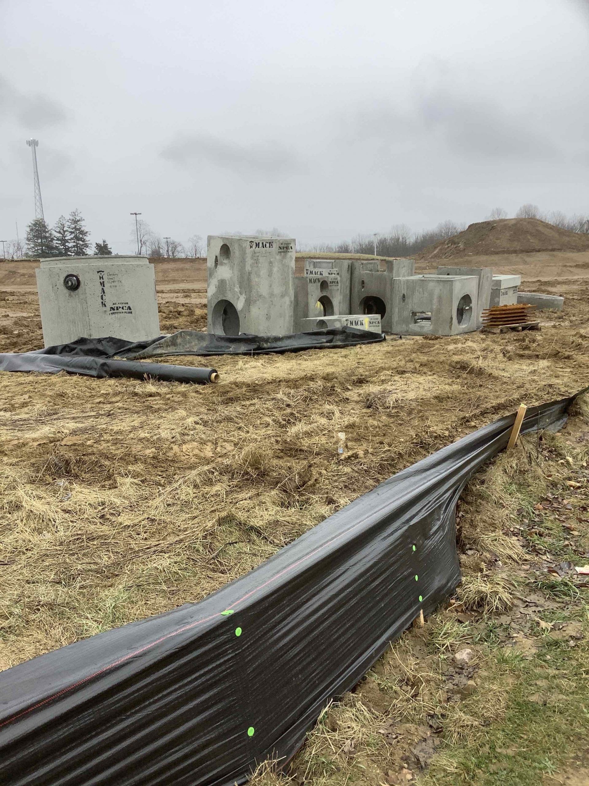A row of concrete blocks are sitting on top of a dirt field.