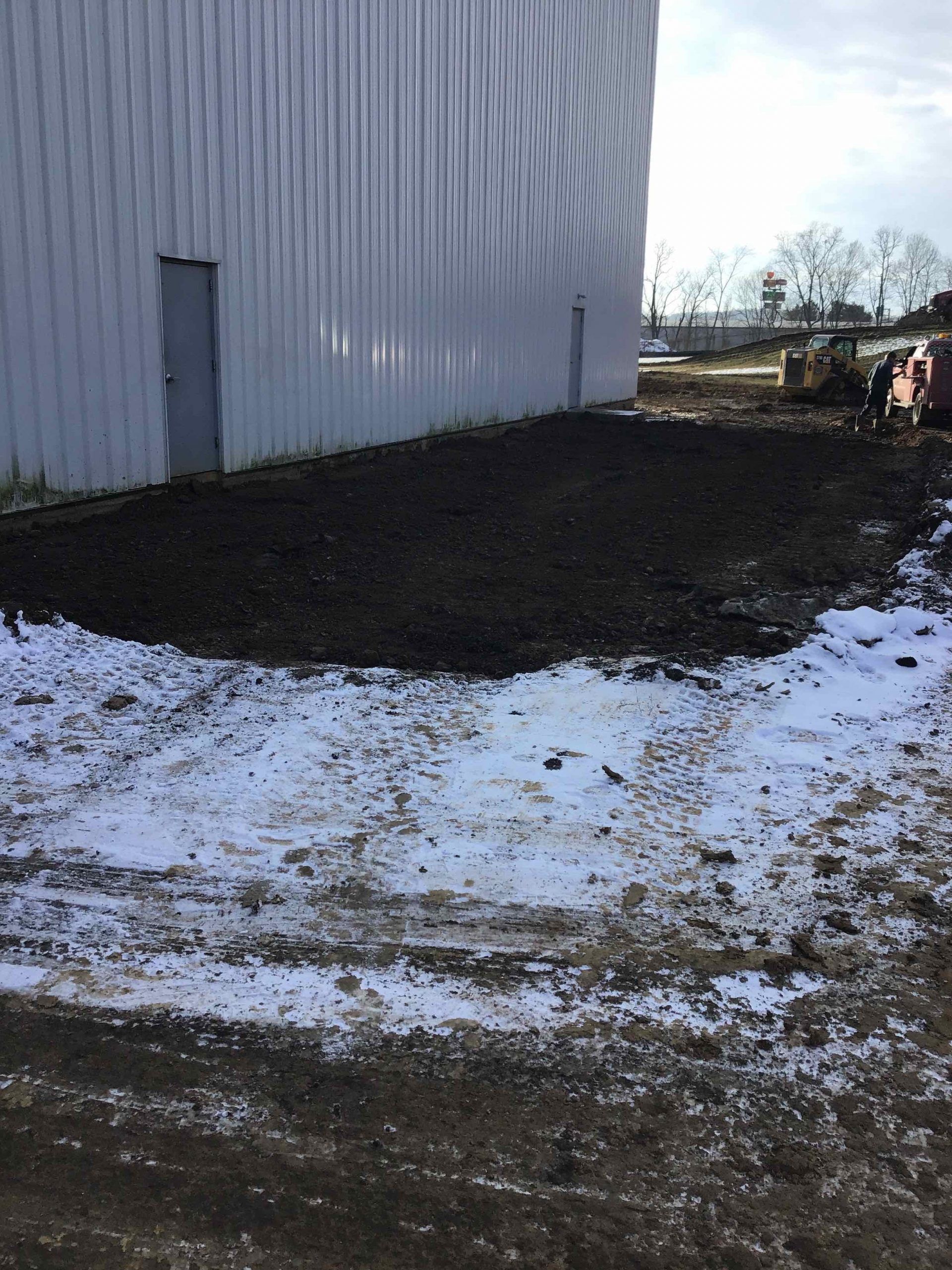 There is a lot of snow on the ground in front of a building.