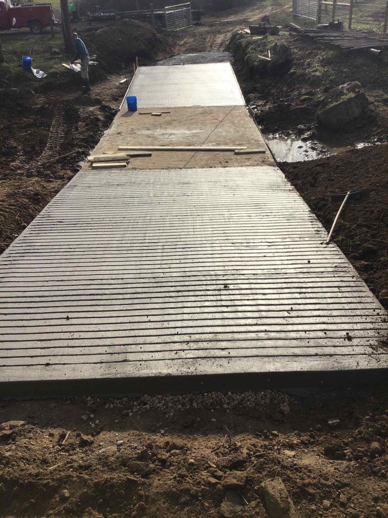 A concrete walkway is being built in the dirt.